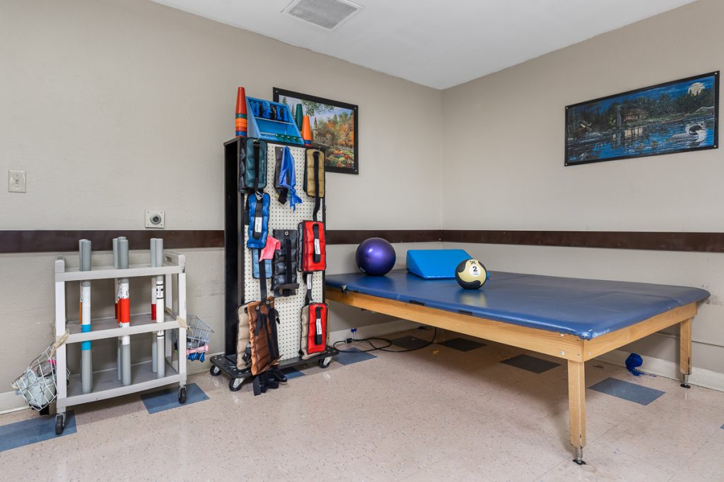 Therapy treatment room with exercise mat and equipment at Edmonds Care